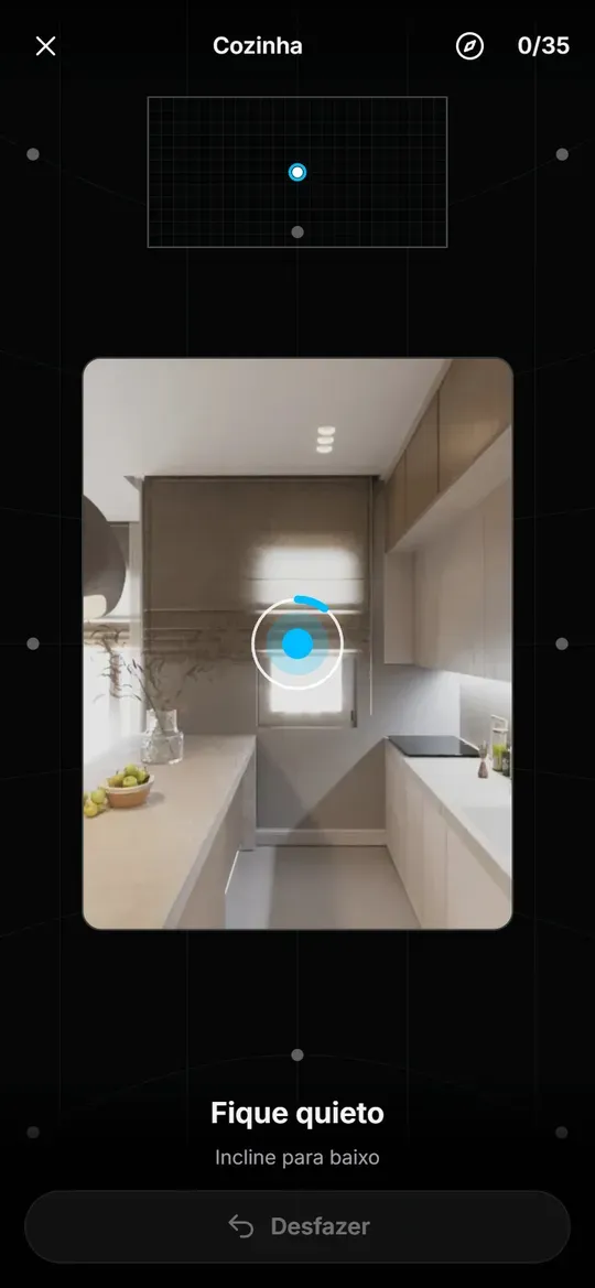 Ecrã de captura num telemóvel com uma cozinha vista pela câmara, um círculo com um ponto azul para seguir, a indicação "Fique quieto" em baixo e um mapa das fotos no topo